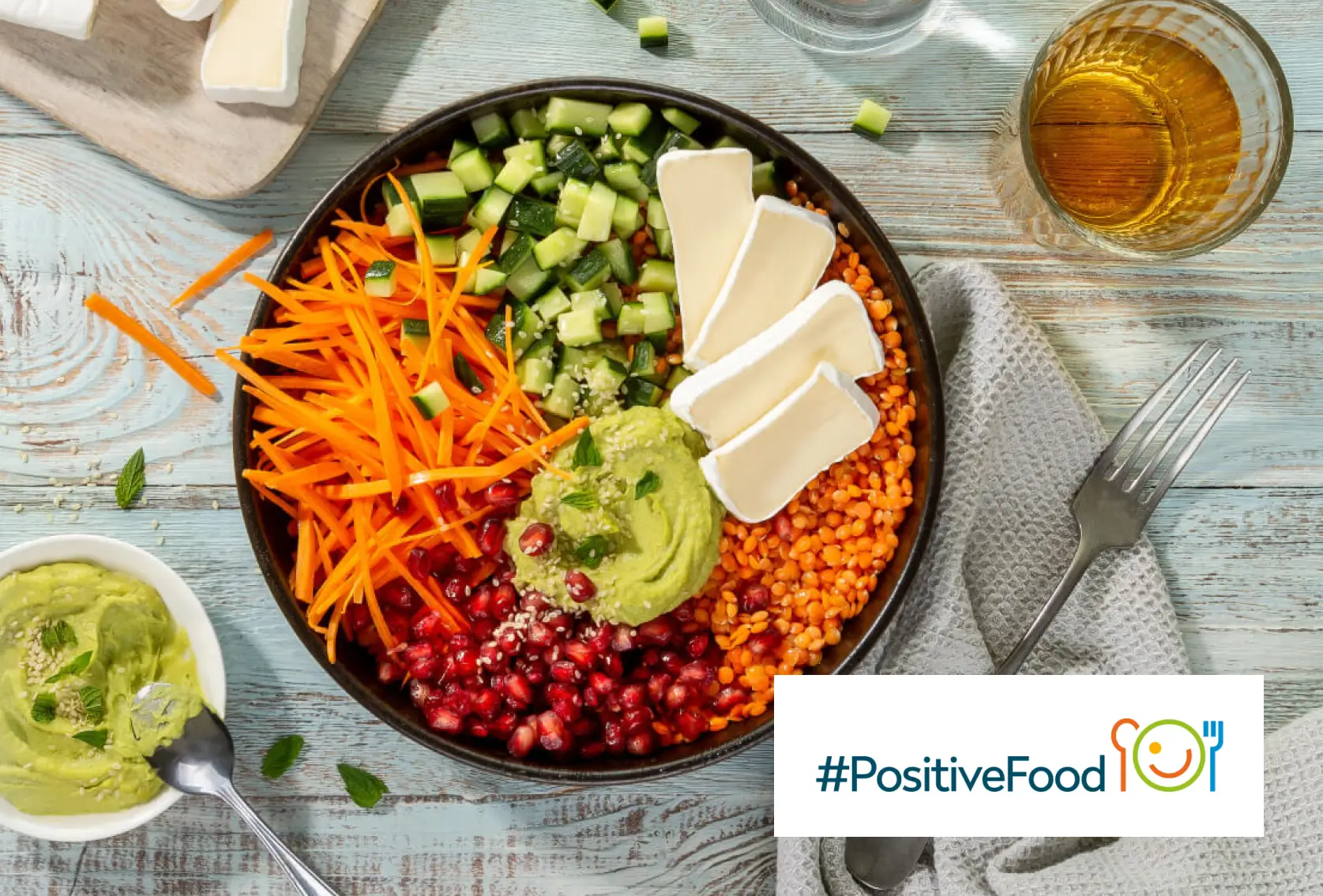 vegetables and cheese in a bowl sitting on a table, viewed from above, with the #PositiveFood logo in the corner